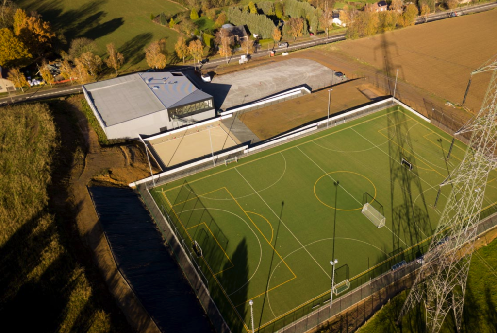  vue aérienne sur l'infrastructure sportive à Ittre Virginal. Terrain synthétique de Hockey, parkings et salle polyvalente de Virginal